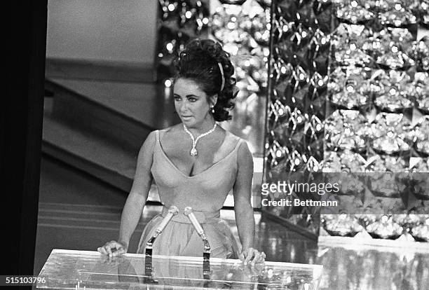 Wearing a beautifully displayed million dollar diamond and low-cut gown, actress Elizabeth Taylor presents an "Oscar" for the best movie in the 42nd...