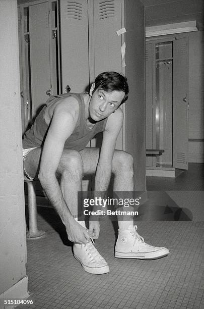 New York Knick's Bill Bradley is photographed here trying on sneakers in dressing room.