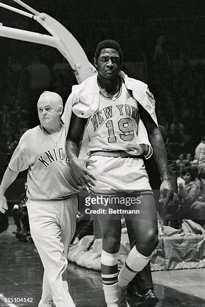Knick's Willis Reed limped off the court after his injury here. His injury resulted in the need for him to be accompanied by trainer Danny Whalen, in...