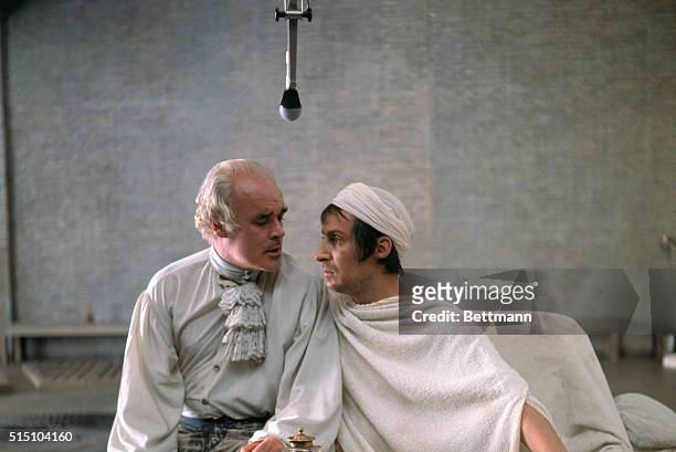 Two actors are shown as they perform in the Persecution and Assassination of Marat which was performed by the inmates of the asylum of Charenton...