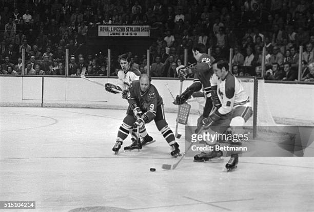 Bobby Hull , of the Chicago Black Hawks, and Jacques LaPerriere , of the Montreal Canadiens, battle for the puck during this Stanley Cup playoff...