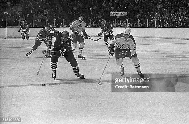 Chicago's Bobby Hull heads an attack across the Canadiens' blue line as he is closely watched by Montrealer Rejean Houle . Other players seen in this...
