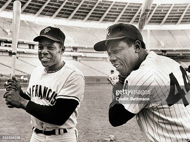 Home run sluggers Willie Mays and Hank Aaron pose in uniform with bats. Mays and Aaron are two of the three major league players who have belted over...