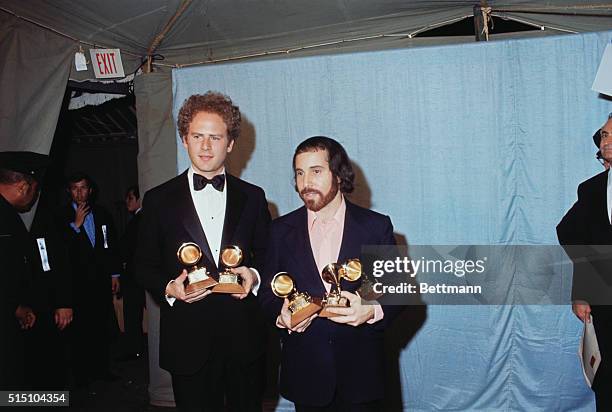 Arthur Garfunkel and Paul Simon hold a Grammy for best record and best album of the year for "Bridge Over Troubled Water." Simon holds a third Grammy...