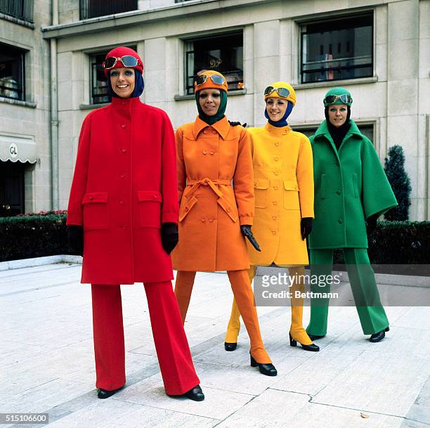Fashion models model brightly colored sports coats with matching hats, and slacks or long spat type stockings, by Guy Laroche from his Winter and...