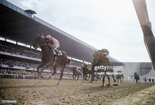 Elmont, New York: Pass Catcher in the lead, as horses in Belmont Stakes come down the home stretch. Jockey is Walter Blum. Pass Catcher won; Jim...