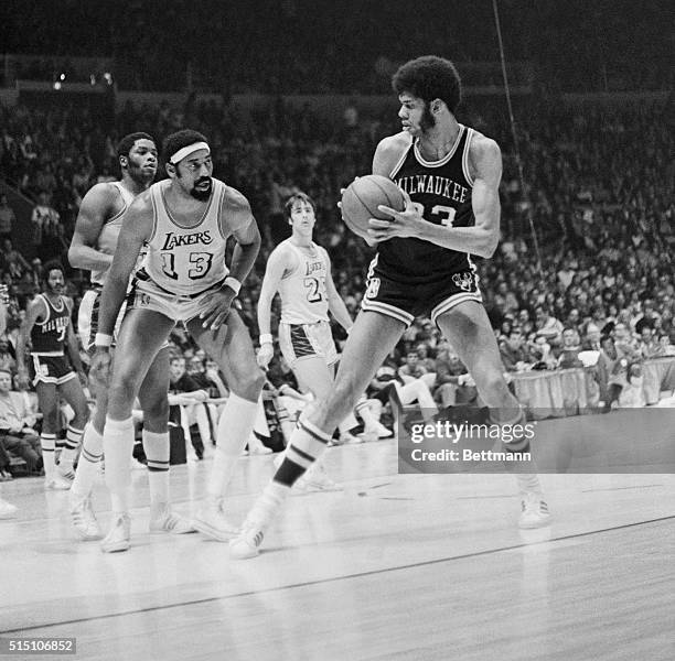 Inglewood, Calif.: Two of basketball's giants stare at each other as Milwaukee Buck Lew Alcindor tries to decide if he should go over Los Angeles...