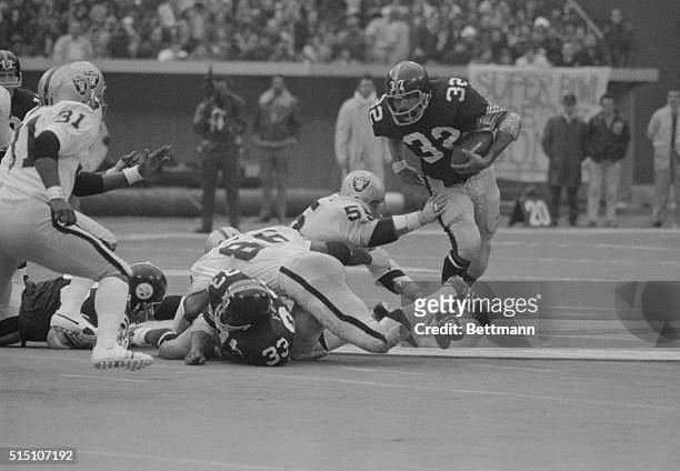 Playoff game- Steeler running back Franco Harris picks up a couple of yards in the 2nd quarter before being pulled down by Oakland Raiders Gerald...