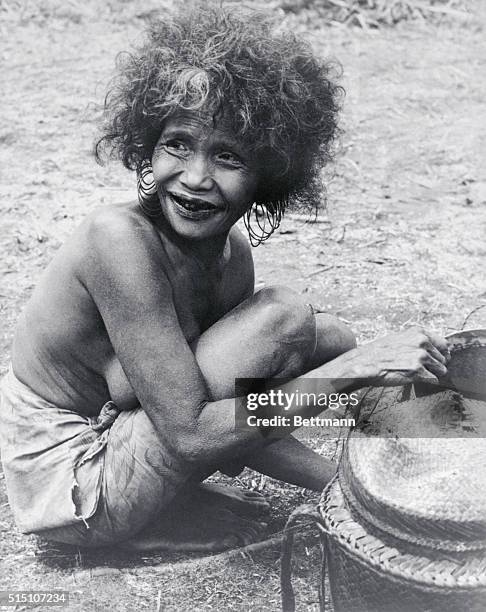 Live in Stone Age Conditions. Manilla: At left a G-stringed boy closes his eyes in fear of the camera while at right a baby has his hair picked of...