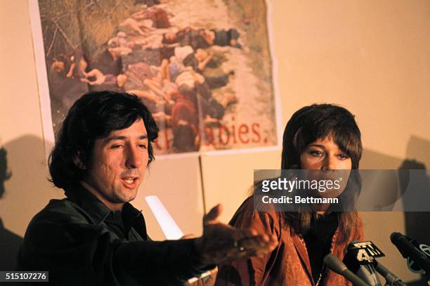 New York, N.Y.: While his fiancee, actress Jane Fonda looks on, anti-war activist Tom Hayden gestures during a news conference on the Vietnam...