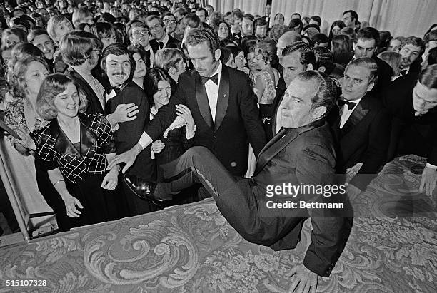 Washington, D.C.: President Nixon climbs up on stage to address guest during an inaugural ball at the Sheraton Hotel. The chief executive danced with...