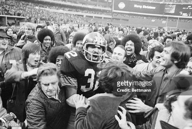 Pittsburgh Steelers' running back Franco Harris is mobed by fans at Three Rivers Stadium after scoring the winning touchdown, nicknamed the...
