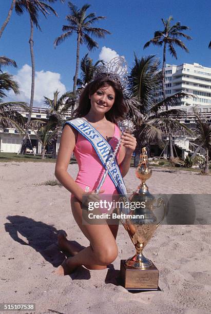 Miami Beach, Fla.: Miss Lebanon, Georgina Rizk is shown with crown, cup and sceptre on beach here the morning after she became Miss Universe. The...