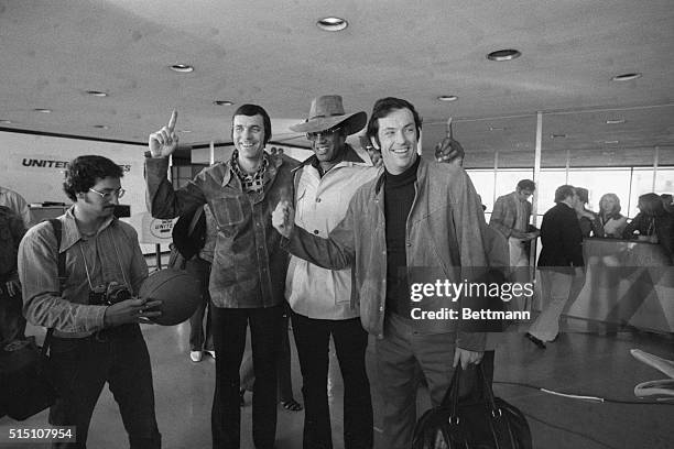 Bill Bradley is shown standing with Willis Reed, , and other Knick players at an airport.