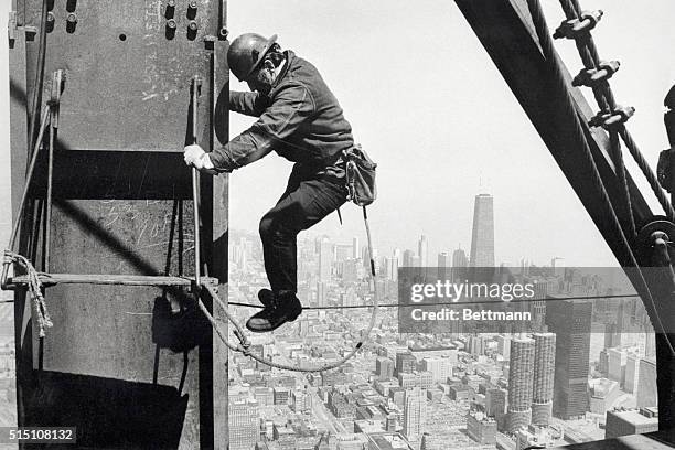 Chicago: "Job at the Top!" An iron worker, completely oblivious to his precarious perch, goes about the task of constructing the top floors of the...