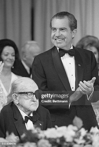 Beverly Hills, Calif.: President Nixon applauds when film director John Ford introduced to the people attending a dinner at the Beverly Hilton Hotel...