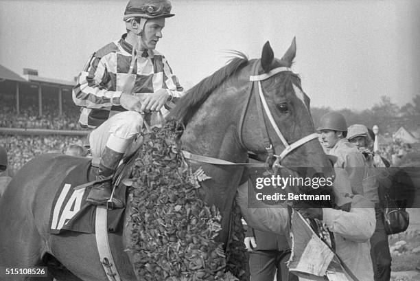 Secretariat is d rapped with roses after winning the Kentucky Derby with jockey Ron Turcotte aboard.