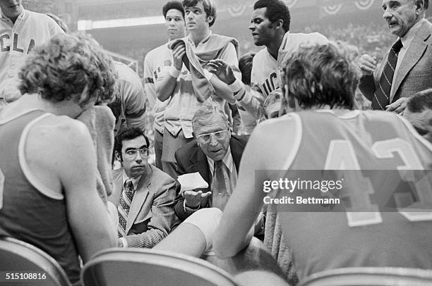 St. Louis: John Wooden, UCLA basketball coach, shown talking to his team during a time out and on the bench during his teams victory in the NCAA...