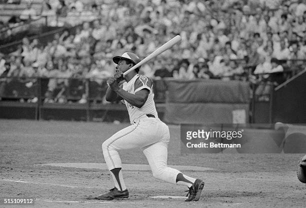 Slugger Hank Aaron of the Atlanta Braves leans into home run number 709 on his tiptoes in this photograph, as he drills the ball over the left field....