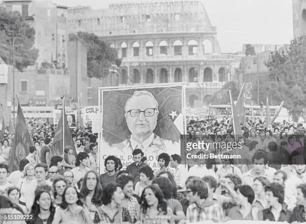 Rome: Demonstrators protesting the Army coup in Chile march past the Colosseum, September 12, carrying a large portrait of the late Chilean President...