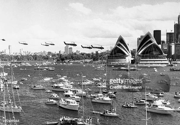 Army helicopters fly over some of the 2,000 yachts and ships during the opening of the Sydney Opera House 10/20 by Queen Elizabeth.