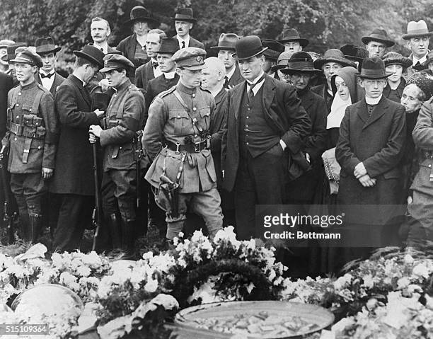Ireland: The Funeral Of Michael Collins. Capt. O'Reilly with Sean Collins, Miss Collins and Sister Celestine, beside grave of Michael Collins...