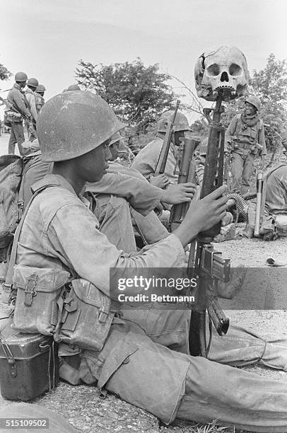 Highway 2, Cambodia: With a skull on the muzzle of his M-16 rifle, a Khmer Rouge government soldier with his comrades-in-arms waiting for the word to...