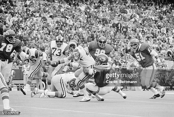 Los Angeles Rams running back Jim Bertelsen fumbles the ball in the first period as he is tracked by Kansas City Chiefs linebacker Willie Lanier ....