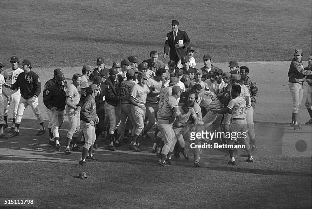 Pete Rose of Reds is restrained by coach Ted Kluszewski and Johnny Bench after fight broke out near second base in 5th inning of playoff game against...