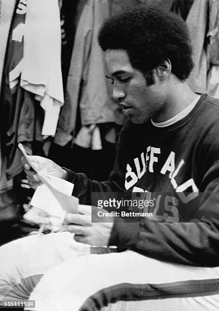 Buffalo Bills', O.J. Simpson, takes a few minutes to read a few Christmas cards in the Bills dressing room after the morning practice at Rich...