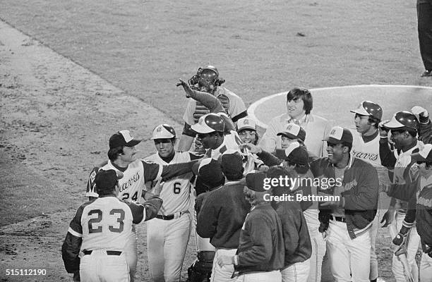 With his hand held aloft, Hank Aaron leaps into a host of cheering teammates after he hit his 715th home run on April 8th . The homer came in the 4th...