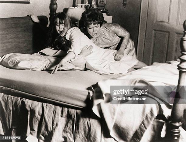 Picture shows actress, Ellen Burstyn, struggling to keep her daughter, actress Linda Blair, in her bed during a scene from the 1973 movie "The...