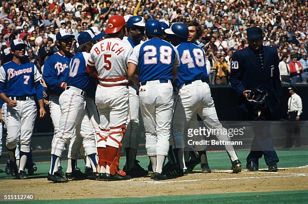 Hank Aaron of the Atlanta Braves is surrounded here by members of his own team, as well as by Reds, after hitting his 713th home run .