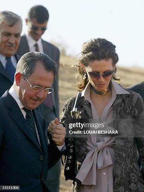 Syria's First Lady Asma al-Assad holds her father Fawaz's hand as she tours the historic Syrian city of Ebla, 300 kms north of Damascus, 20 October...