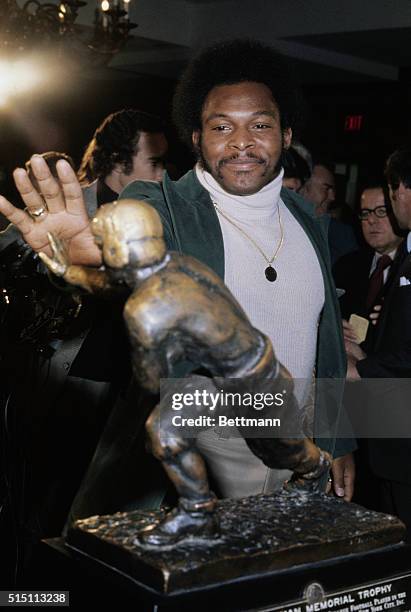 Archie Griffin of Ohio State poses with the Heisman Trophy he won as the outstanding college football player in the nation. He became the first...