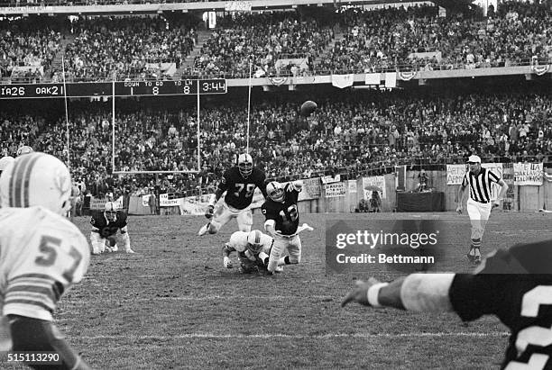 Oakland Raiders quarterback Ken Stabler is hit from behind by Miami Dolphins defensive end Vern Den Herder as he lets go the winning touchdown pass...