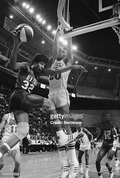 New York Nets' Julius Erving drives against Spirits of Louis' Maurice Lucas as he goes under the basket to make a layup in the first period of the...