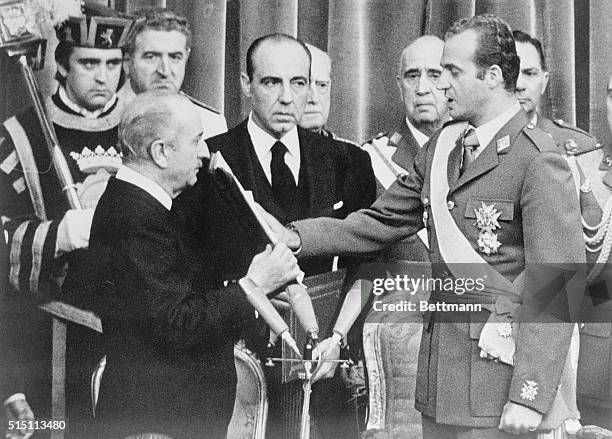 Madrid: Hand placed on the Bible, Prince Juan Carlos takes the oath of his throne in the Cortes Building in Madrid as the monarchy is reintroduced in...