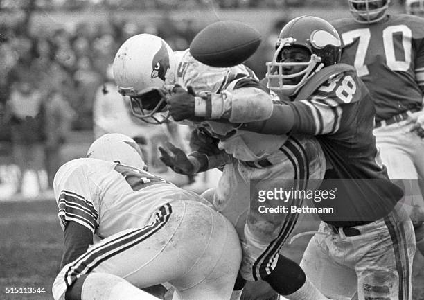 The ball pops up as Cardinals' Terry Metcalf, , fumbles as he is grabbed by Vikings' Alan Page, . Metcalf's fumble was recovered by the Vikings,...