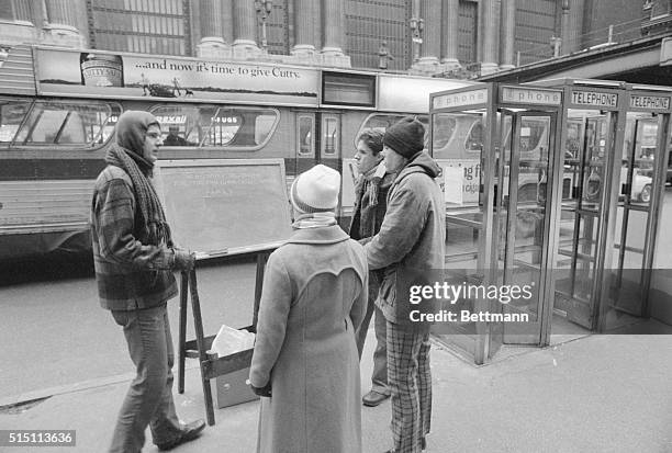 Young male "moonie" or follower of the Reverend Sun Myung Moon and the Unification Church, lectures potential recruits on the sidewalk of 42nd...