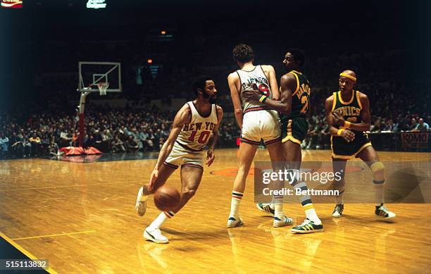 New York Knicks guard Walt Frazier is screened by Phil Jackson to elude Spencer Haywood and Slick Watts of the Seattle Supersonics.