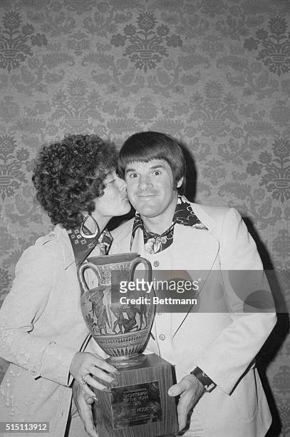 Third baseman Pete Rose of the Cincinnati Reds is rewarded with a cup and a kiss by his wife Karolyn for being named Sportsman of the Year by Sports...