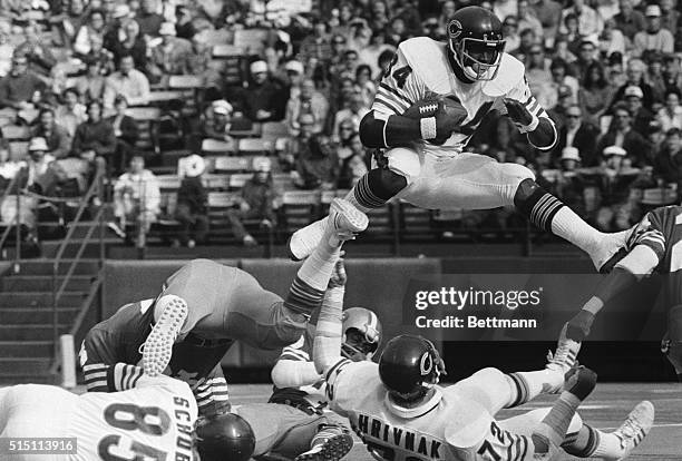 Chicago Bears' Walter Payton hurdles over fallen teammate Gary Hrivnak as he returns the kickoff in the first quarter. Payton took the kickoff two...