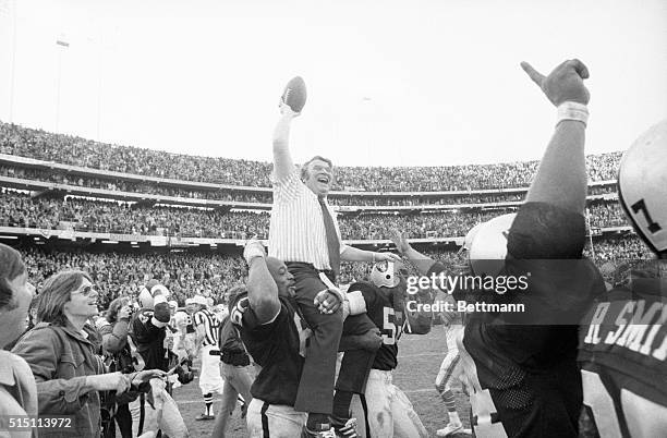 Oakland Raiders' coach John Madden holds the game ball high in the air as he rides the shoulders of Otis Sistrunk and Gary Weaver following Raiders...