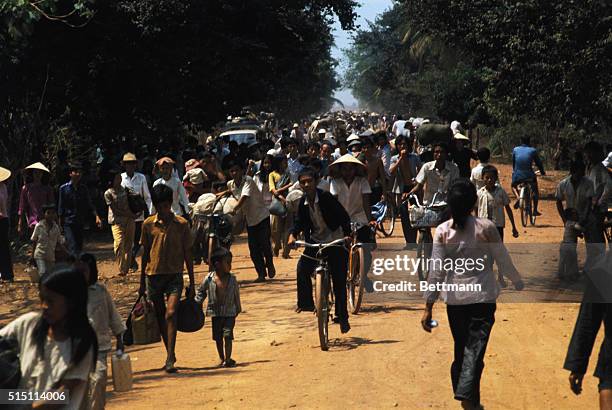 Villagers flee down highway as Communists advance in Dau Tieng, 35 miles north of Saigon. Blown-up bridges blocked 3/19 the escape route for a convoy...