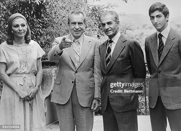 Former President Richard Nixon points to newsmen he recognizes as he finishes a one day visit with the Shah of Iran at the home where the Shah is...