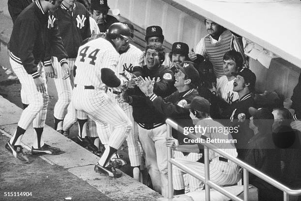 Yankee slugger Reggie Jackson receives congratulations from skipper Billy Martin and his teammates following his third consecutive home run during...