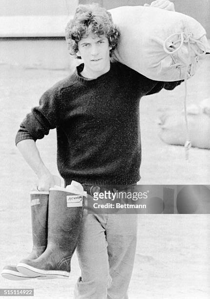 July 12, 1977-Rockland, Maine: John F. Kennedy Jr. Carries seabag and boots as he heads down to dock here to take part in 26-day exercise.
