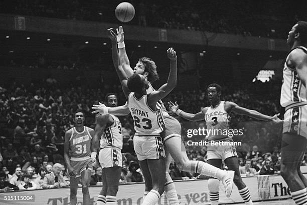 Houston Rocket guard Mike Newlin charges into and shoots over Sixers forward Joe Bryant during a game at the Spectrum Sports Arena in Philadelphia.