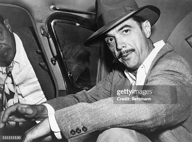 Howard Hughes seated in an automobile.